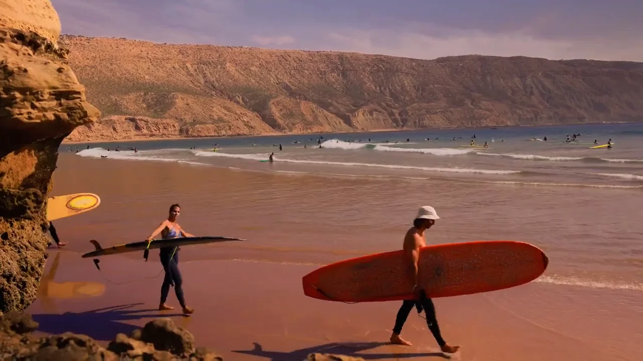 Moniteurs et élèves de surf de Skate Surf Camp Morocco sur la plage de Tamraght