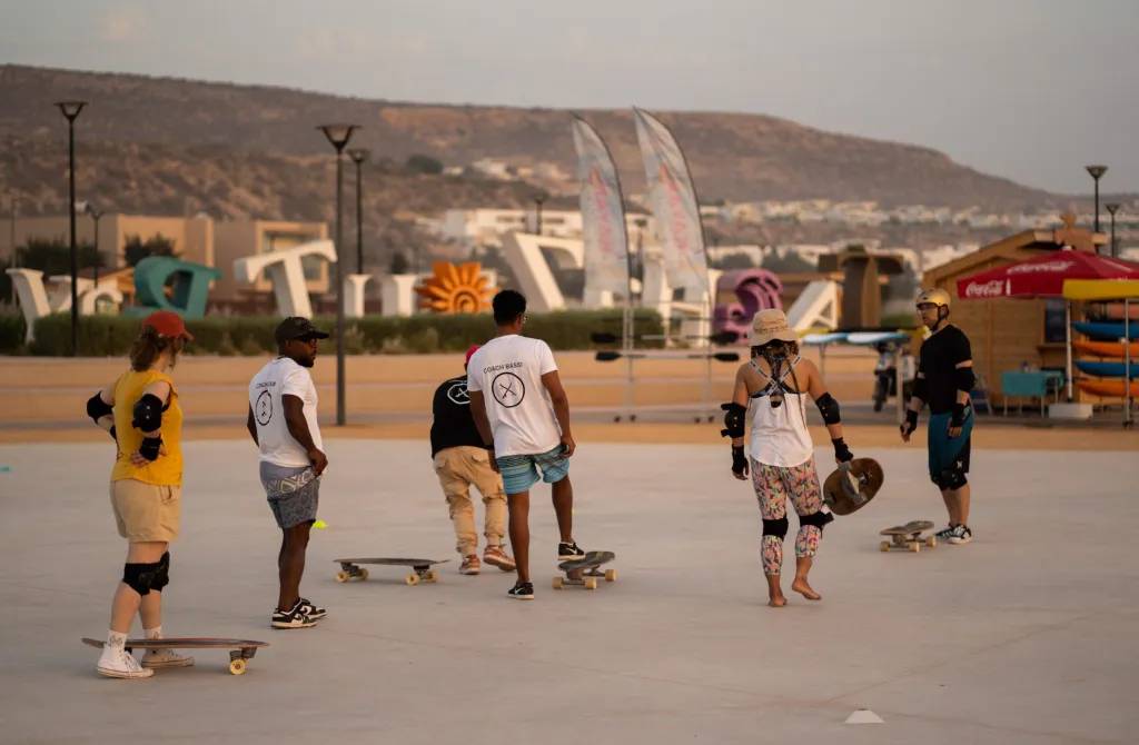 Session de surf-skate encadrée sur la plaza côtière au coucher du soleil