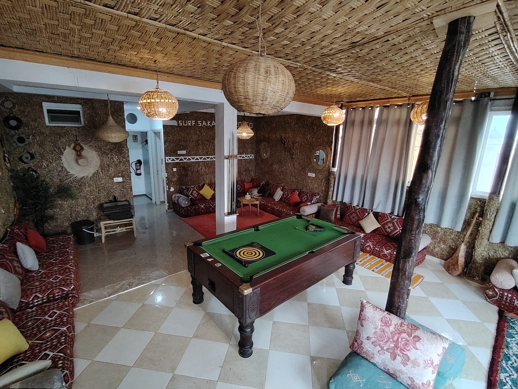 Salon berbère avec banquettes basses, tapis et billard